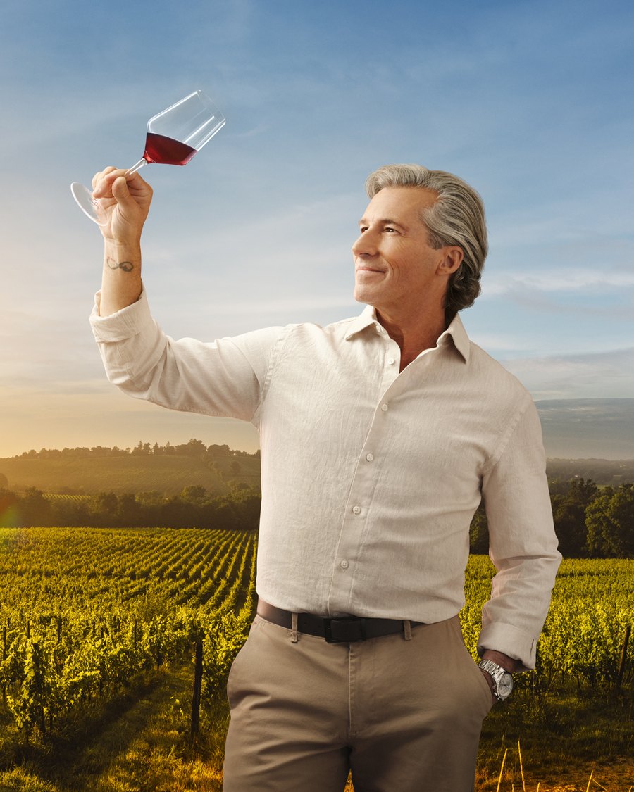 Dany Gagnon raising a glass of red wine in a vineyard at golden hour